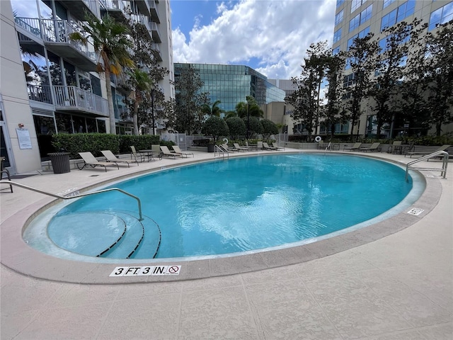 community pool with fence and a patio area