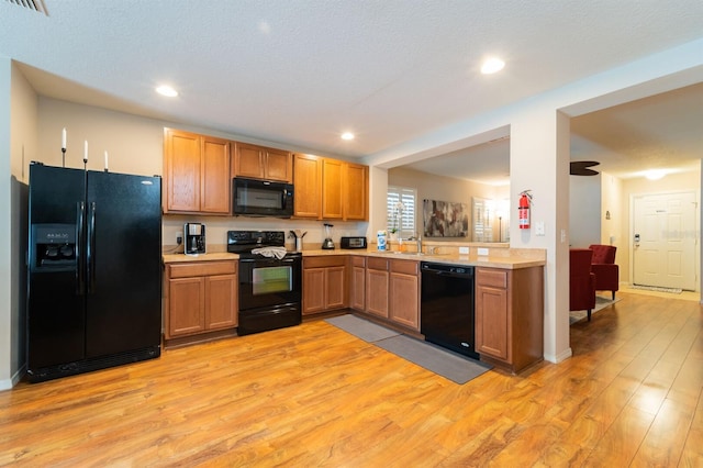 5101 Staniard Dr, Kissimmee, FL 34746 - kitchen with light wood-style flooring, black appliances, recessed lighting, a sink, and light countertops