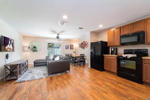 5101 Staniard Dr, Kissimmee, FL 34746 - kitchen featuring open floor plan, light wood-type flooring, visible vents, and black appliances