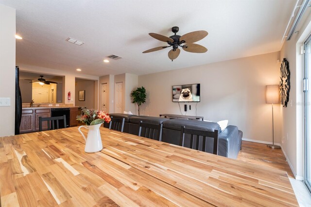 5101 Staniard Dr, Kissimmee, FL 34746 - dining space featuring ceiling fan, visible vents, wood finished floors, beverage cooler, and baseboards