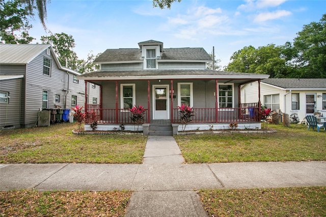 514 Massachusetts Ave, Saint Cloud, FL 34769 - view of front of home featuring a front lawn, a shingled roof, and a porch