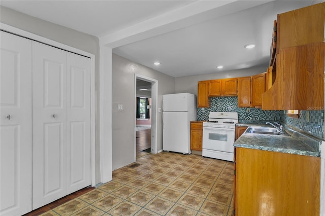 514 Massachusetts Ave, Saint Cloud, FL 34769 - kitchen featuring brown cabinetry, a sink, backsplash, and white appliances