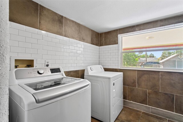 514 Massachusetts Ave, Saint Cloud, FL 34769 - laundry room with washing machine and clothes dryer, tile walls, laundry area, and dark tile patterned floors