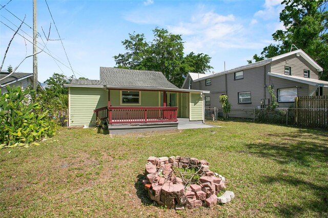 514 Massachusetts Ave, Saint Cloud, FL 34769 - rear view of property with a lawn, a shingled roof, fence, and an outdoor fire pit