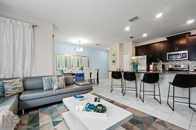 9075 Dogleg Dr, Davenport, FL 33896 - living room with marble finish floor, an inviting chandelier, visible vents, and recessed lighting
