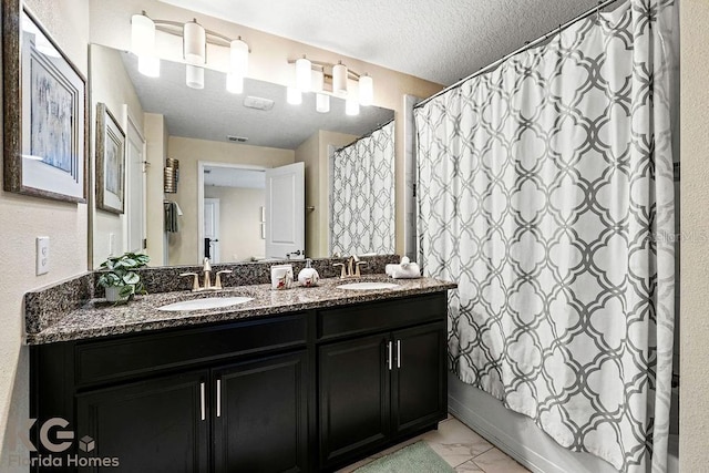 9075 Dogleg Dr, Davenport, FL 33896 - full bathroom featuring double vanity, marble finish floor, a sink, and a textured ceiling