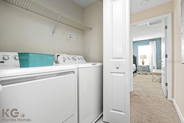 9075 Dogleg Dr, Davenport, FL 33896 - clothes washing area with baseboards, light carpet, visible vents, independent washer and dryer, and laundry area