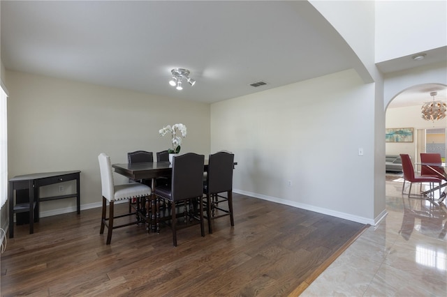 7716 Park Hill Ave, Leesburg, FL 34748 - dining area featuring arched walkways, baseboards, a chandelier, and wood finished floors
