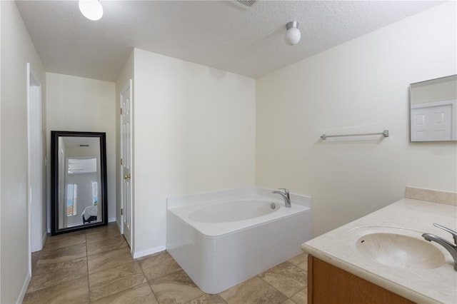 7716 Park Hill Ave, Leesburg, FL 34748 - bathroom featuring a bath, a textured ceiling, vanity, and baseboards