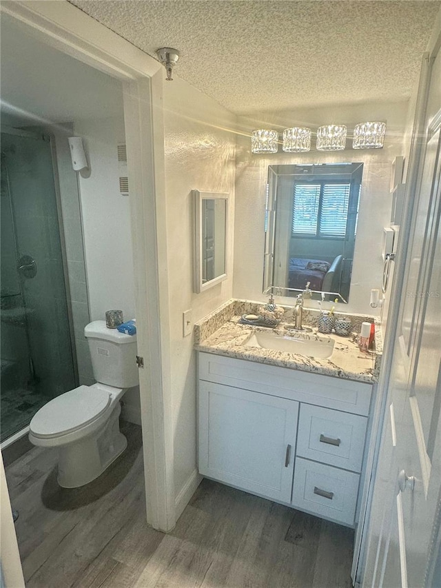 full bathroom featuring a textured ceiling, wood finished floors, and a shower stall
