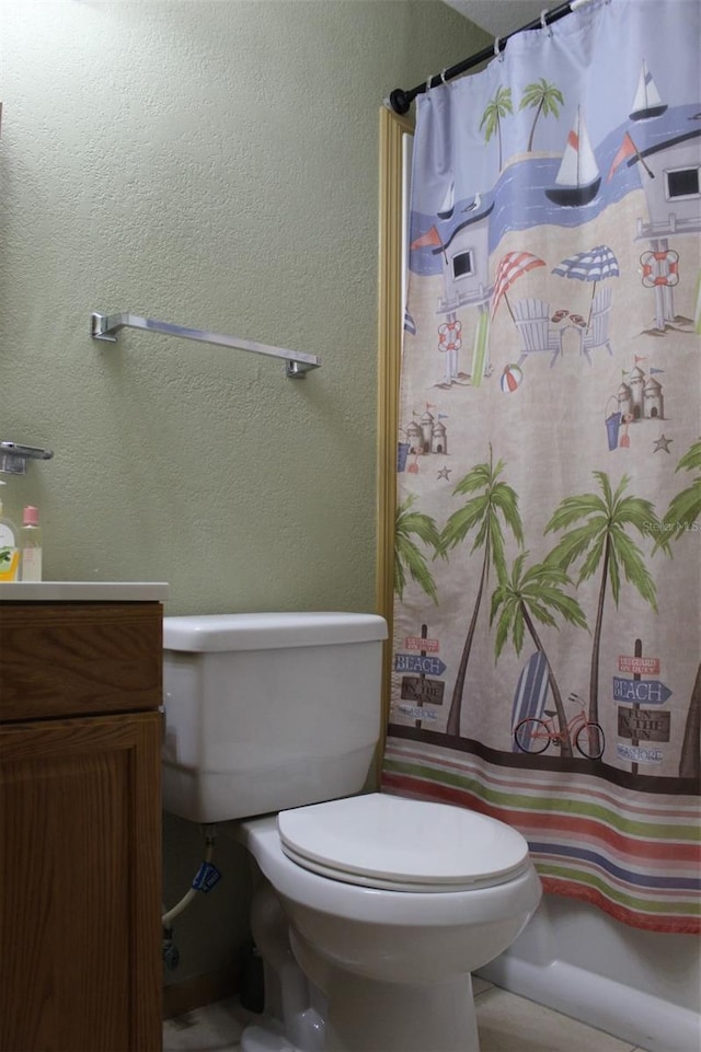 full bath with toilet, a shower with shower curtain, vanity, and a textured wall