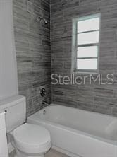 bathroom featuring toilet and bathing tub / shower combination