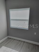 empty room with baseboards and wood finished floors