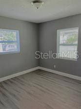 spare room featuring baseboards and wood finished floors
