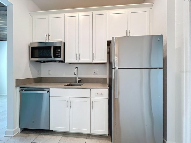 195 Preston Ave, Davenport, FL 33837 - kitchen with white cabinets, stainless steel appliances, light tile patterned floors, and a sink