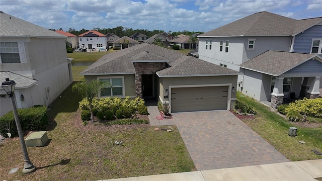 195 Preston Ave, Davenport, FL 33837 - view of front of house with a garage, a shingled roof, a residential view, decorative driveway, and stucco siding