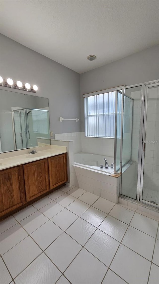 full bath featuring tile patterned flooring, vanity, a stall shower, and a bath