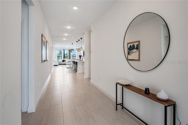 corridor featuring baseboards and recessed lighting