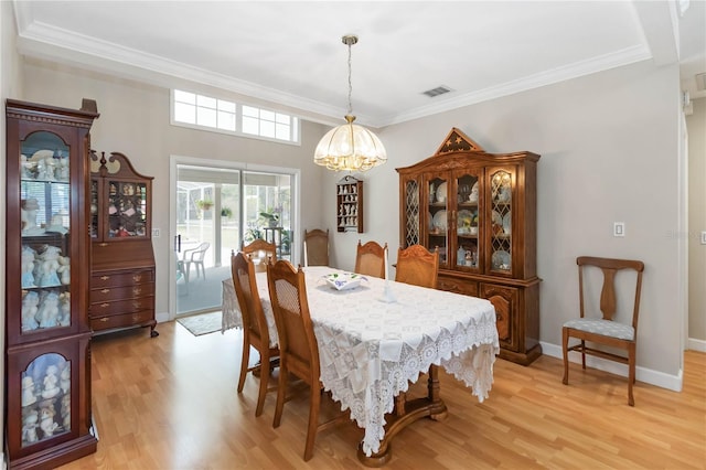 1730 King Henry Dr, Kissimmee, FL 34744 - dining area with crown molding, light wood finished floors, baseboards, visible vents, and an inviting chandelier