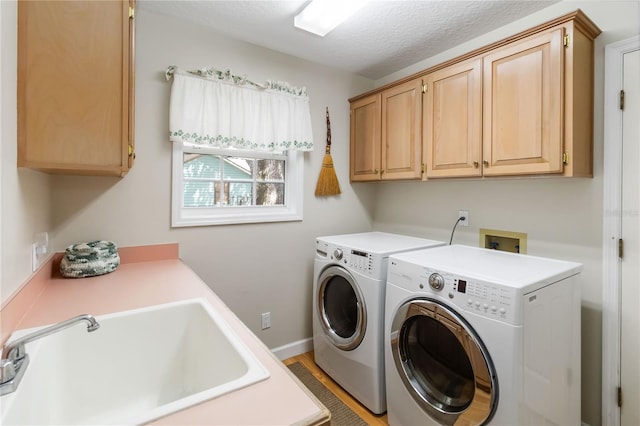 1730 King Henry Dr, Kissimmee, FL 34744 - laundry area featuring baseboards, a textured ceiling, washing machine and clothes dryer, a sink, and cabinet space