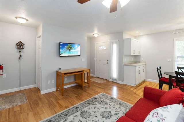 1730 King Henry Dr, Kissimmee, FL 34744 - living room featuring baseboards, a ceiling fan, and light wood finished floors