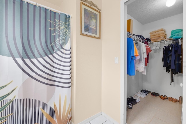 101 Cheltenham Pl, Kissimmee, FL 34758 - interior space featuring a spacious closet, tile patterned flooring, curtained shower, and a textured ceiling