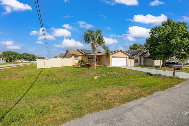 101 Cheltenham Pl, Kissimmee, FL 34758 - ranch-style house with fence, a garage, a front yard, solar panels, and driveway