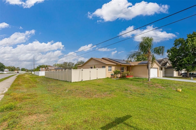 101 Cheltenham Pl, Kissimmee, FL 34758 - exterior space featuring fence, an attached garage, solar panels, a front lawn, and driveway