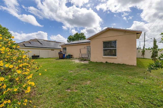 101 Cheltenham Pl, Kissimmee, FL 34758 - rear view of property featuring a fenced backyard, roof mounted solar panels, and a yard