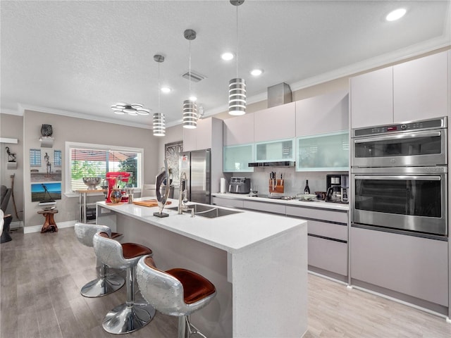 1911 Greenbriar Ter, Davenport, FL 33837 - kitchen with crown molding, a kitchen bar, visible vents, stainless steel appliances, and a center island with sink