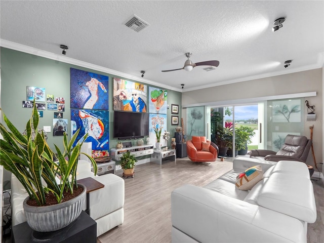 1911 Greenbriar Ter, Davenport, FL 33837 - living area with ornamental molding, a textured ceiling, visible vents, ceiling fan, and wood finished floors