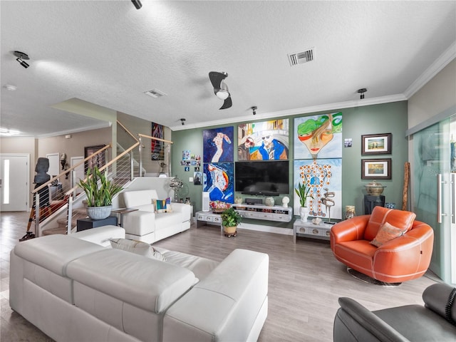 1911 Greenbriar Ter, Davenport, FL 33837 - living area with ornamental molding, a textured ceiling, stairs, visible vents, and wood finished floors