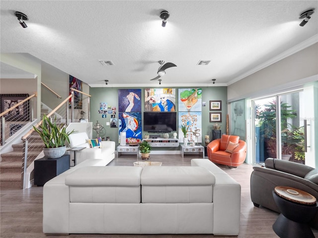 1911 Greenbriar Ter, Davenport, FL 33837 - living room featuring ornamental molding, a textured ceiling, stairs, visible vents, and wood finished floors