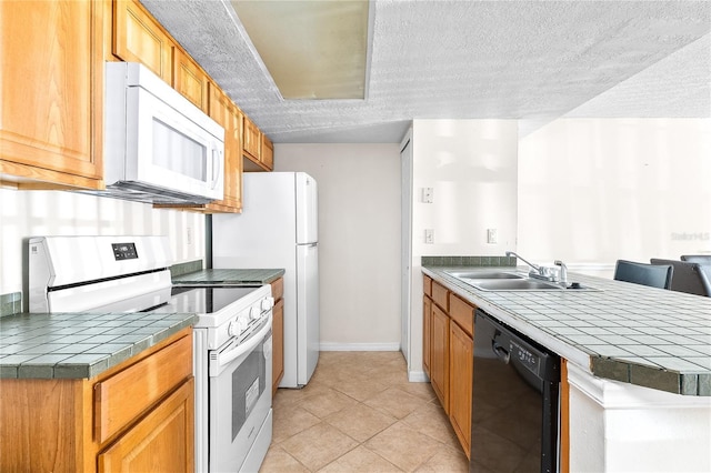 2741 N Poinciana Blvd Unit 49, Kissimmee, FL 34746 - kitchen with a textured ceiling, a peninsula, white appliances, tile countertops, and a sink
