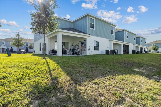 rear view of house with a lawn, a patio, cooling unit, and stucco siding