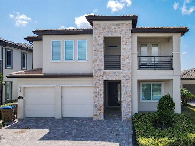 view of front of home featuring a garage, stucco siding, decorative driveway, and stone siding