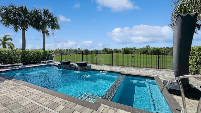 view of swimming pool with fence, a lawn, a patio, and a pool with connected hot tub