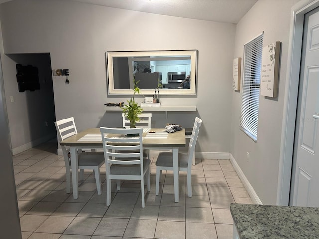 dining room featuring light tile patterned floors and baseboards