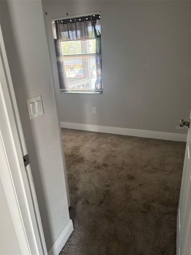 carpeted spare room with baseboards