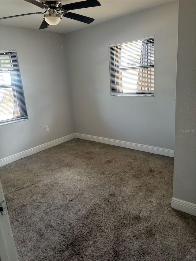 carpeted empty room featuring baseboards and ceiling fan