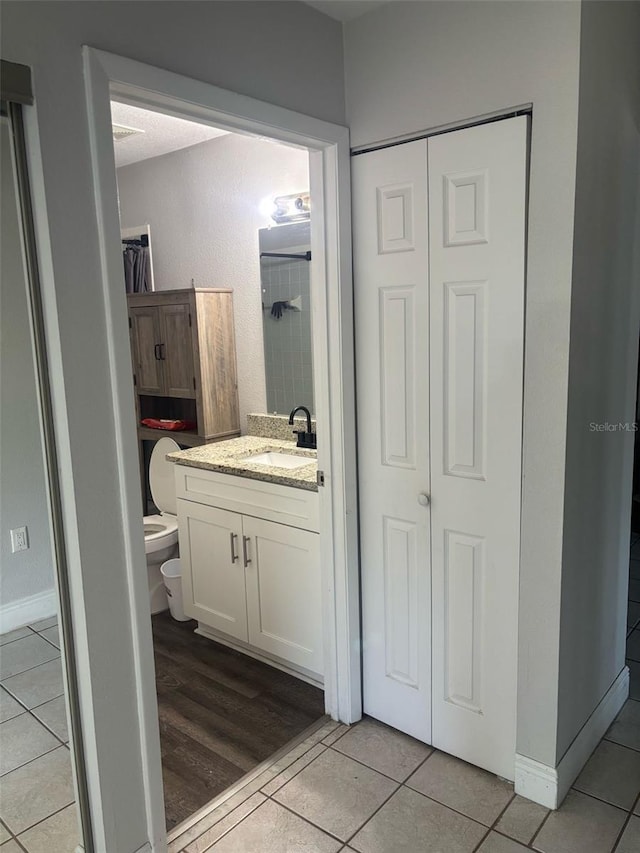 bathroom with tile patterned floors, toilet, and vanity