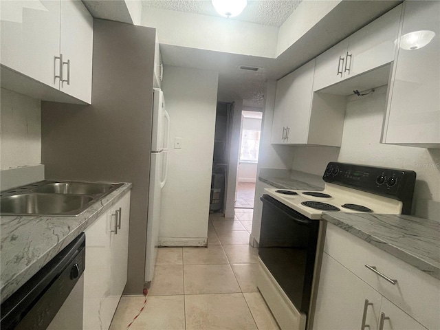 kitchen featuring light tile patterned floors, a textured ceiling, white cabinetry, dishwasher, and range with electric stovetop