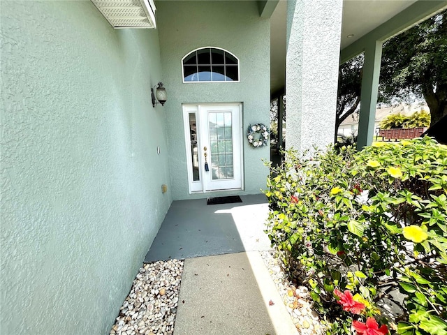 doorway to property featuring stucco siding