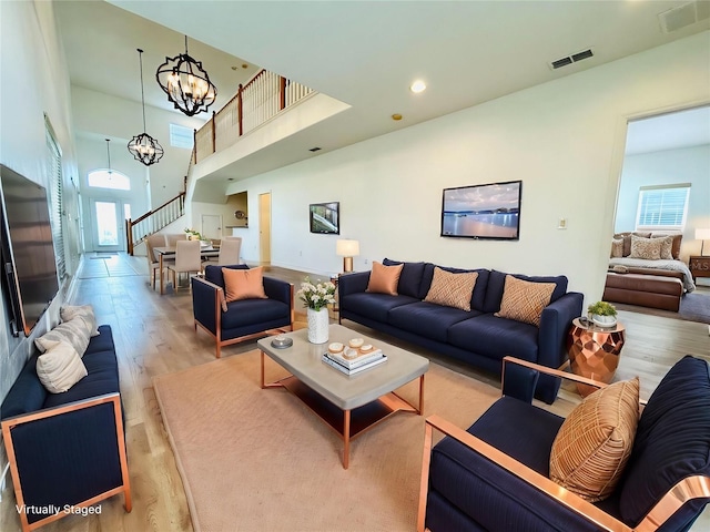 living room with visible vents, a healthy amount of sunlight, wood finished floors, and stairs