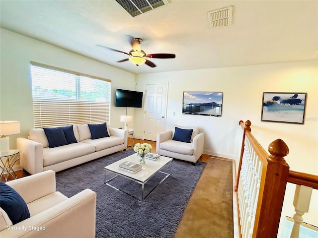living room featuring visible vents, ceiling fan, and baseboards