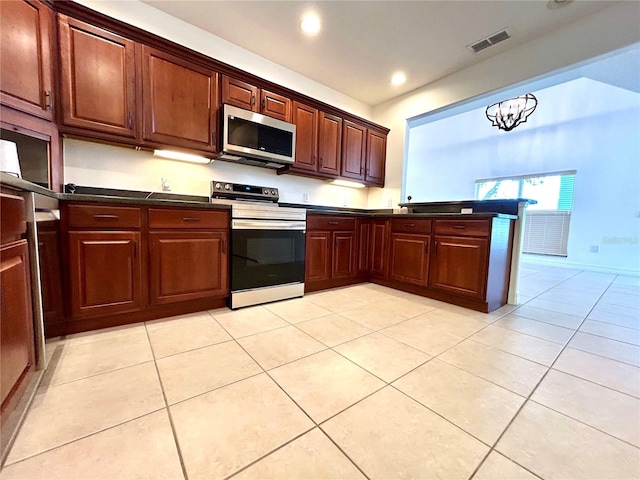 kitchen featuring an inviting chandelier, visible vents, light tile patterned flooring, dark countertops, and stainless steel appliances