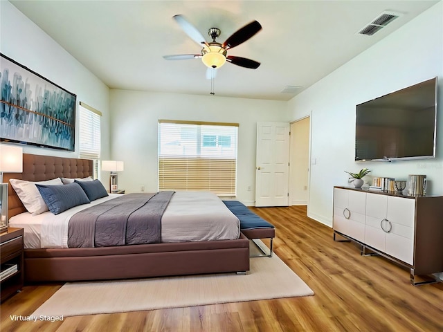 bedroom with visible vents, baseboards, ceiling fan, and wood finished floors