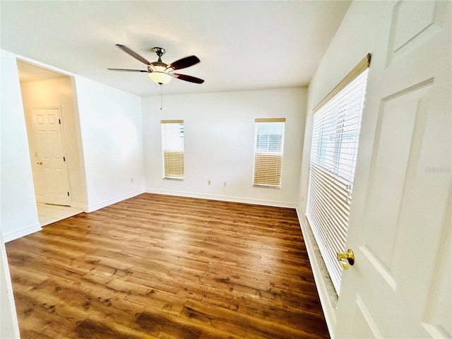 unfurnished room with wood finished floors, a ceiling fan, and plenty of natural light