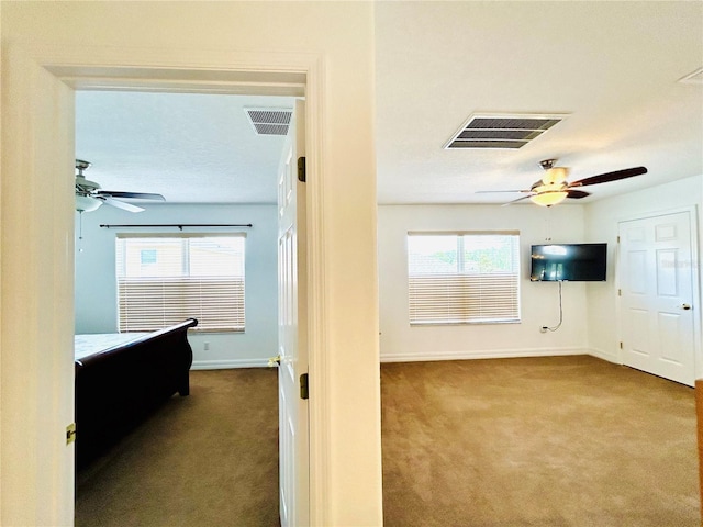 interior space featuring visible vents, baseboards, and dark colored carpet