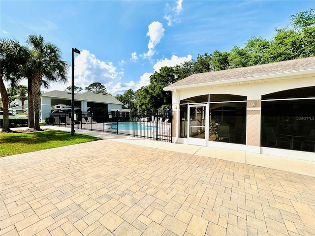 view of pool with a sunroom, a patio, a fenced in pool, and fence